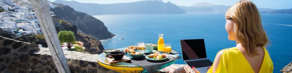 Woman working with laptop while on vacation in Mediterranean