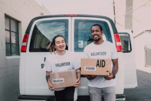 Two male nonprofit organization volunteers holding boxes