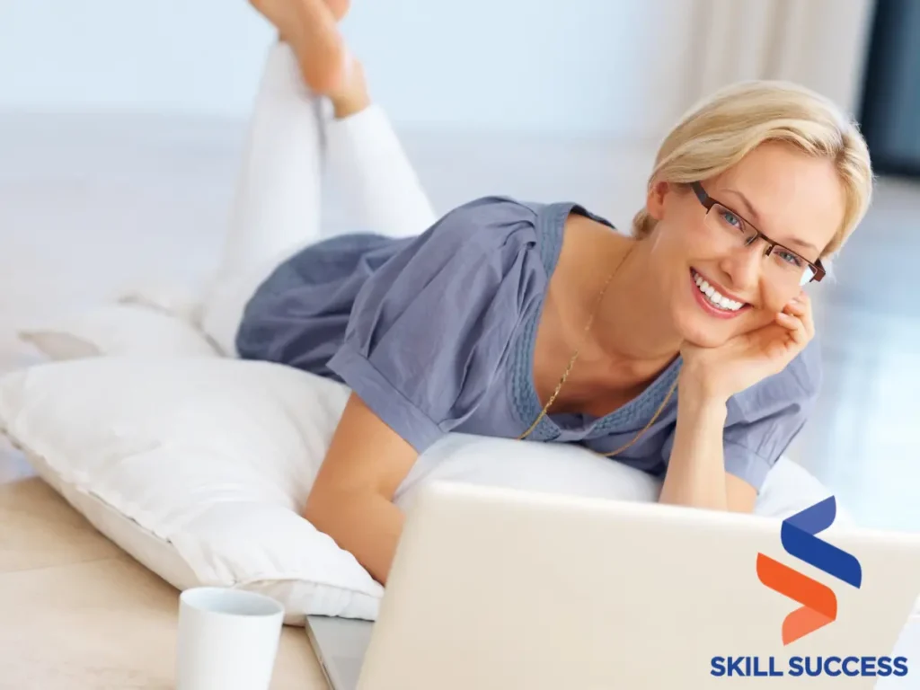 Image of a woman on a bed with a laptop, engaged in personal development