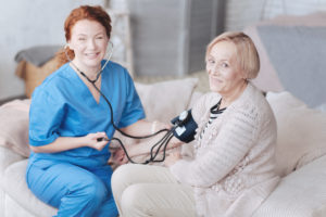 senior-lady-smiling-while-measuring-blood-pressure-by-a-licensed-practical-and-licensed-vocational-nurse