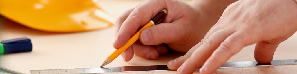 arms-of-worker-making-structure-plan-on-scaled-paper-closeup