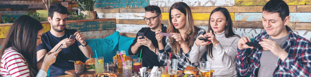 social-media-addiction-concept-with-young-people-photographing-food-in-rustic-restaurant-happy-friends-taking-picture-of-pizza-and-hamburgers-with-mobile-phones-to-post-online-connecting-millennials
