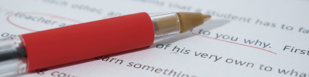 red-pen-on-english-grammar-text