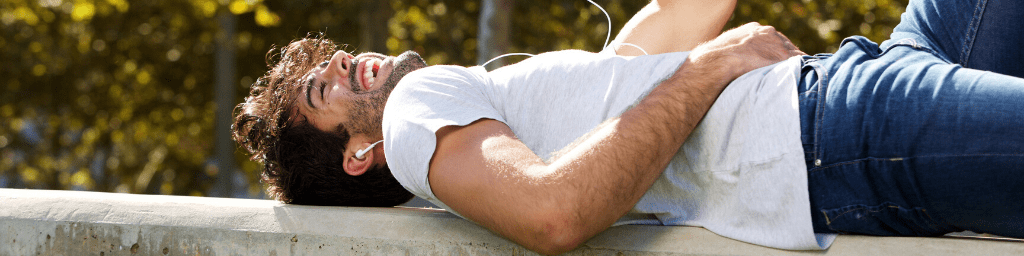 happy-man-lying-on-wall