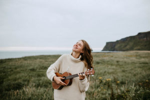 happy woman playing ukulele in Iceland