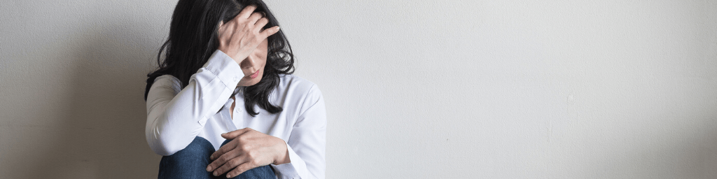 stressful-woman-sitting-sadly-with-emotional-depression-and-anxiety-on-the-floor-in-home-living-room-with-white-wall