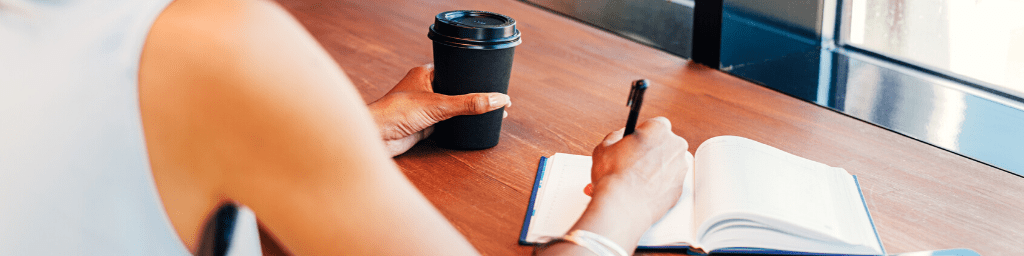 young-entrepreneur-taking-notes-in-cafe