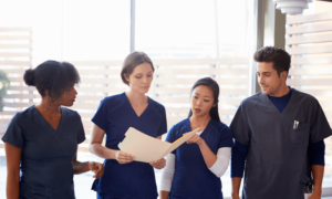 healthcare-colleagues-discussing-notes-in-hospital-corridor