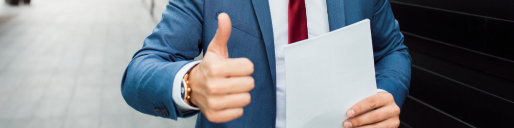 businessman doing thumbs up sign, holding a letter
