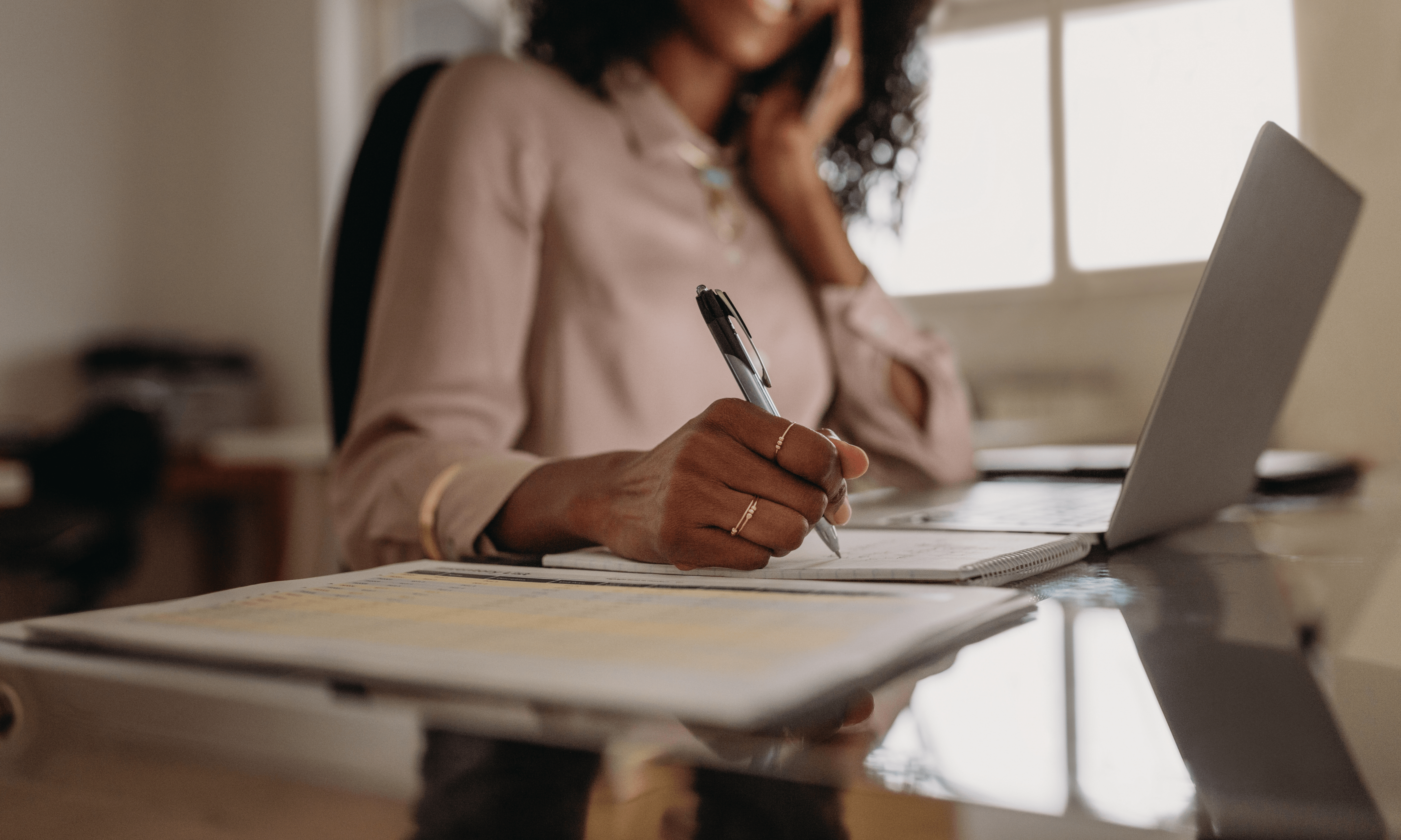woman-making-notes-working-on-laptop-at-home