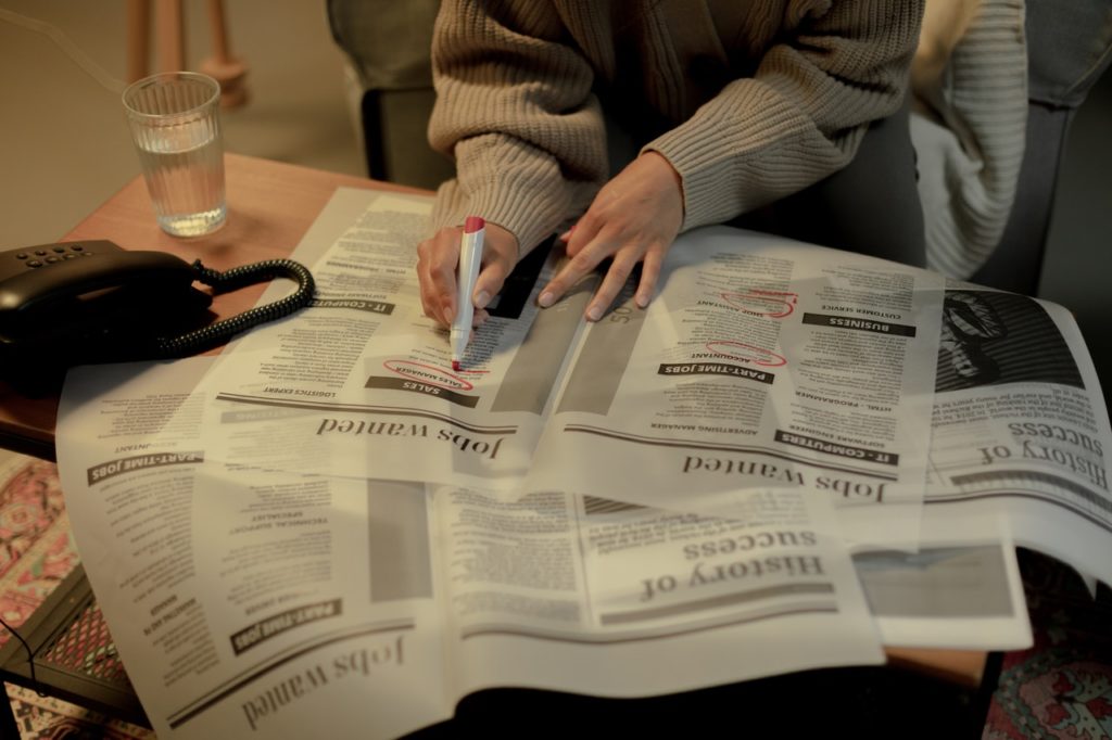 woman looking for jobs in news paper