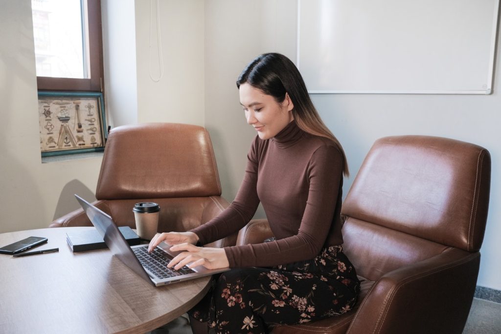 female job seeker typing resume on laptop