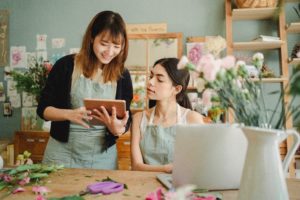 two women with laptop in floral shop