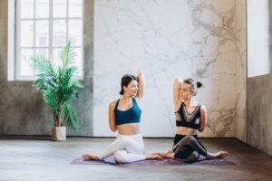 two women sitting on galaxy design kundalini yoga mat