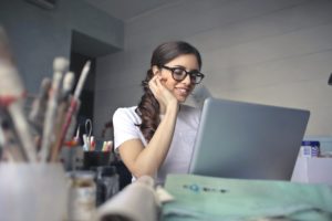 female executive assistant wearing black framed eyeglasses sitting on chair