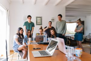 group of young professionals looking at laptop