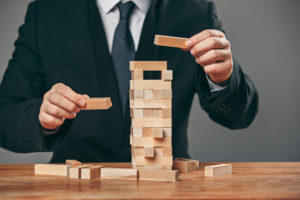 Man and wooden cubes on table management concept