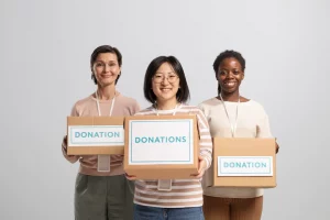 Volunteers holding boxes containing donations for charity