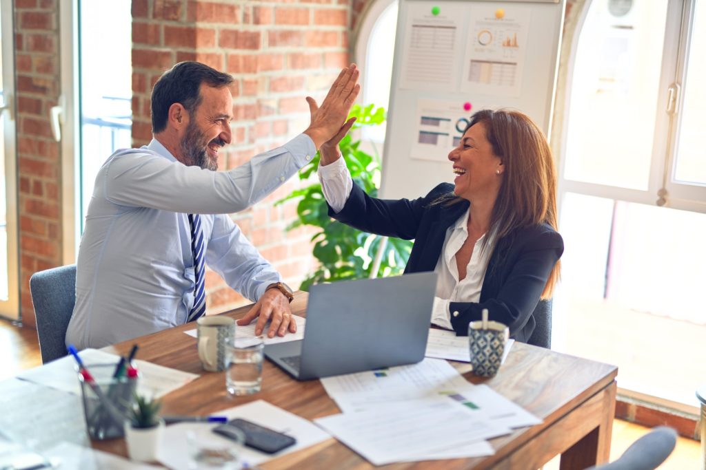 Two middle age business workers smiling happy and confident