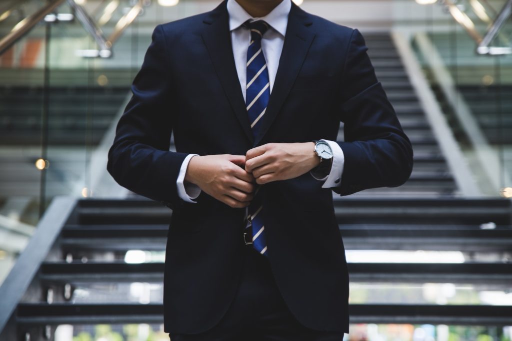 person in suit standing near stairs career progression