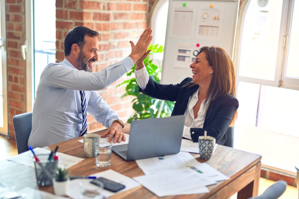 co workers giving high five in the workplace coaching