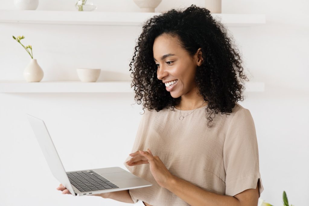 female student holding laptop and smiling