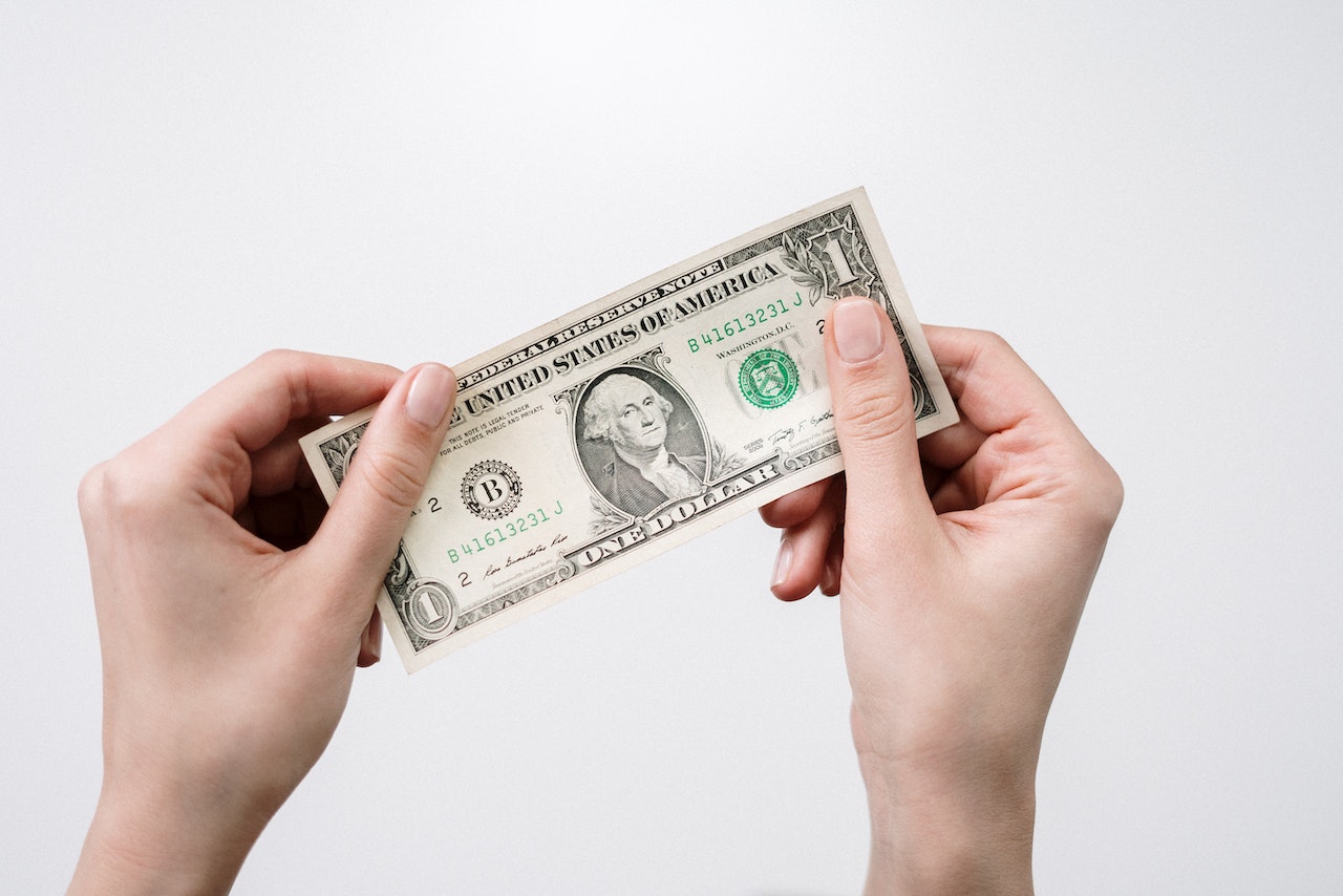 person holding dollar bill