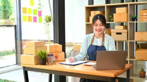 Ecommerce Tools Female Business Owner Shelves Boxes Laptop