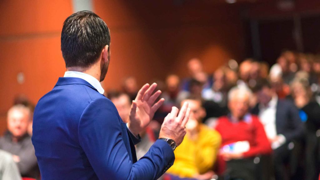 effective speech man in blue suit talking to audience