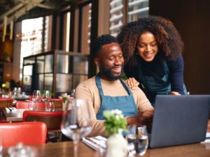 small business owners using laptop in restaurant