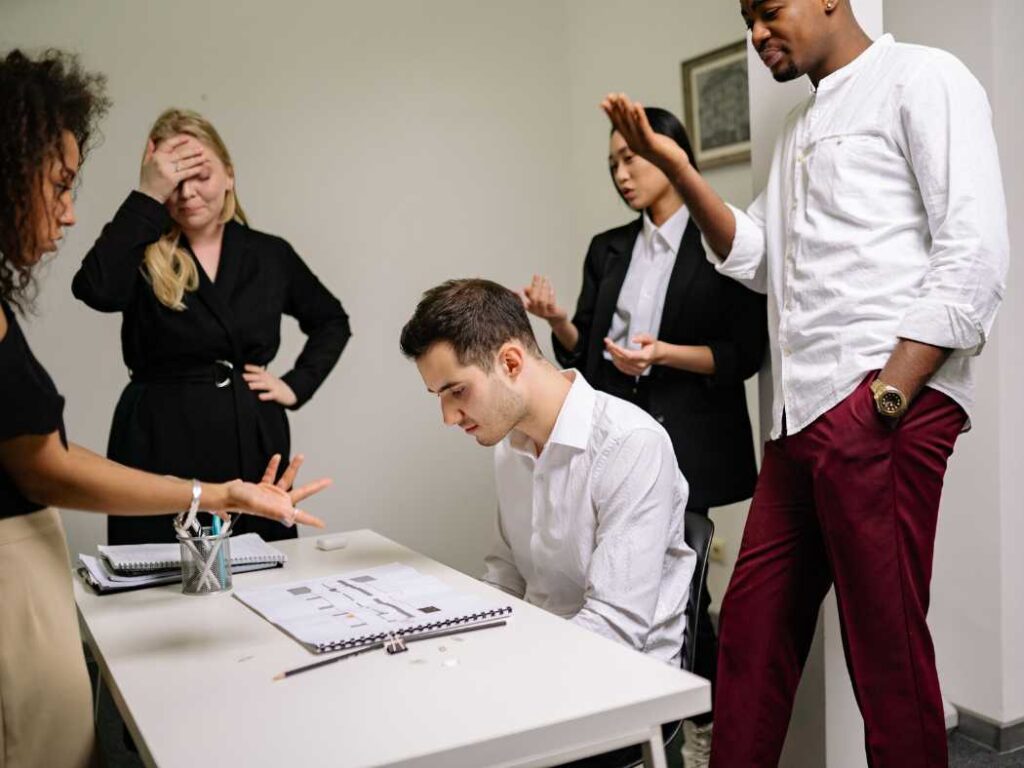 man being bullied and abused by colleagues in the workplace