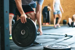 man holding weight plate in gym