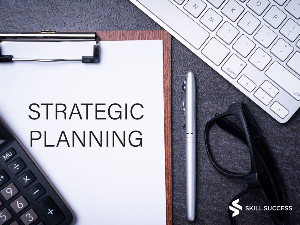 Strategic Planning written on paper with a keyboard and pen next to it.