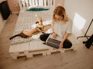 a woman studying online lifestyle courses with her dog