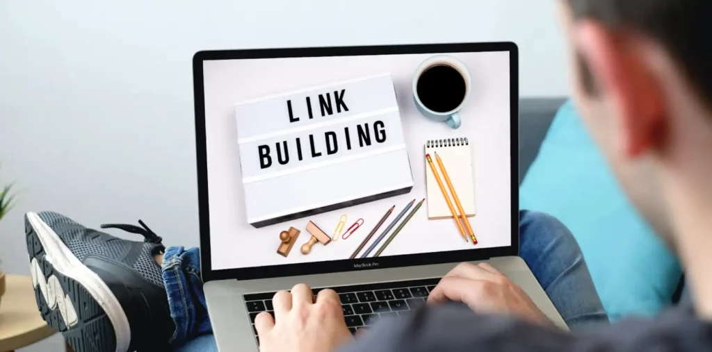 person typing on laptop with link building as wallpaper