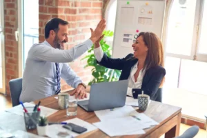 coworkers smiling and exchanging high fives