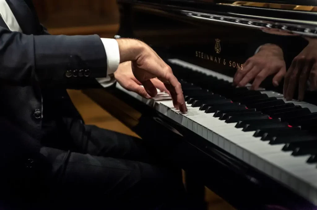 adult playing grand piano