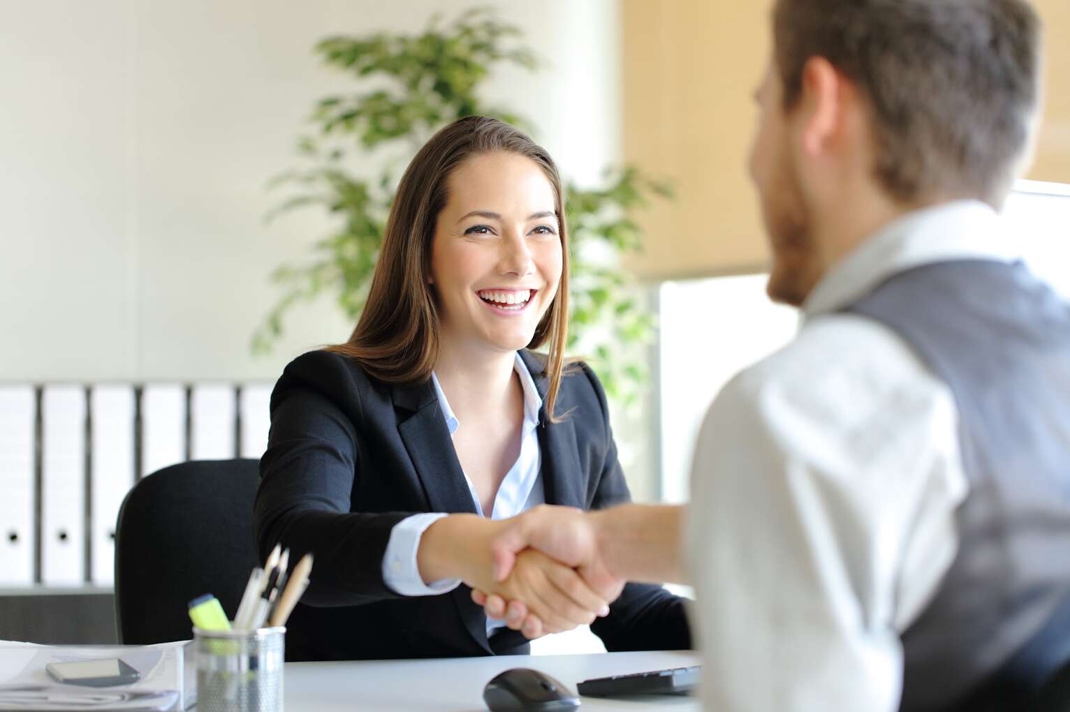 female applicant shaking hands with job interviewer