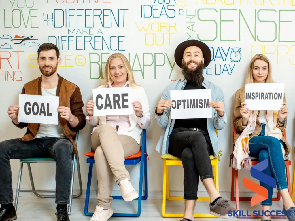 Five individuals seated, each holding a sign with words "care," "passion," and "compassion" - depicting the goals of Psychology