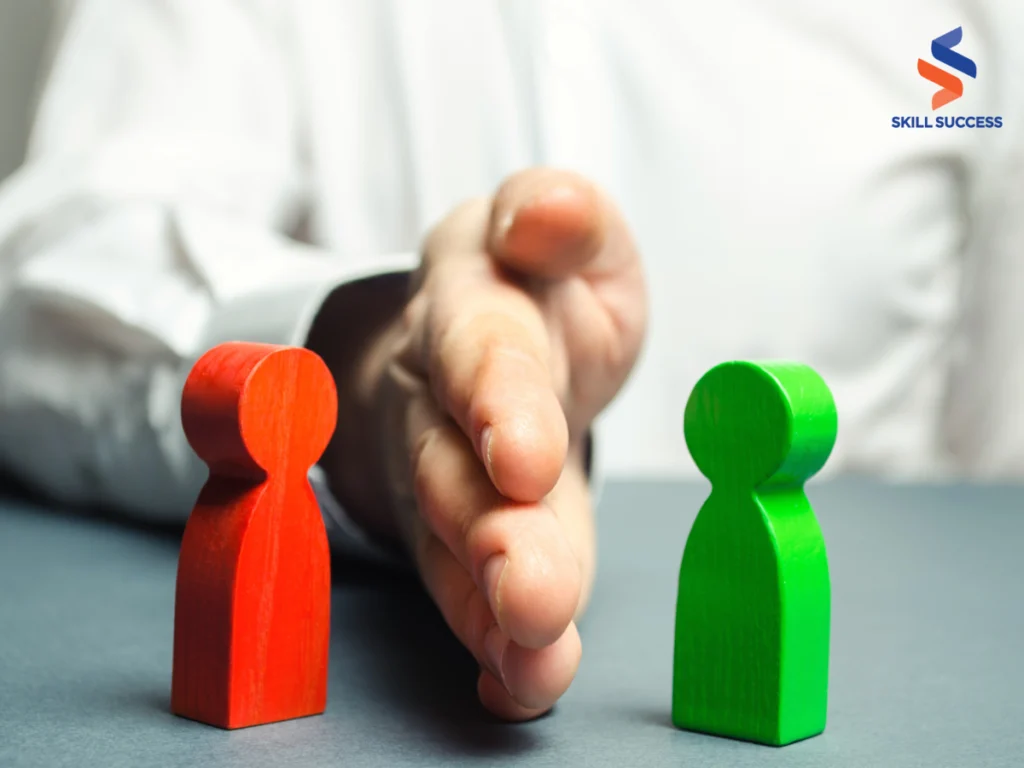 A person holding a green and red figure in front of a wooden figure, demonstrating conflict resolution skills in business