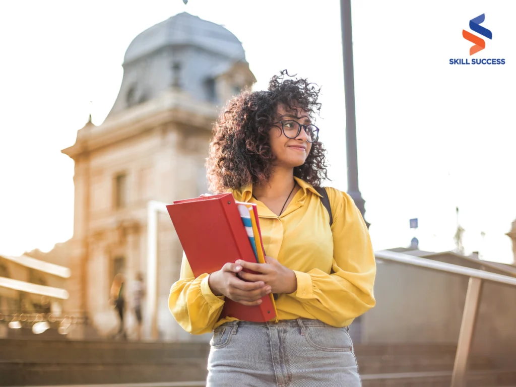 A student holding a book, learning how to be financially independent from parents