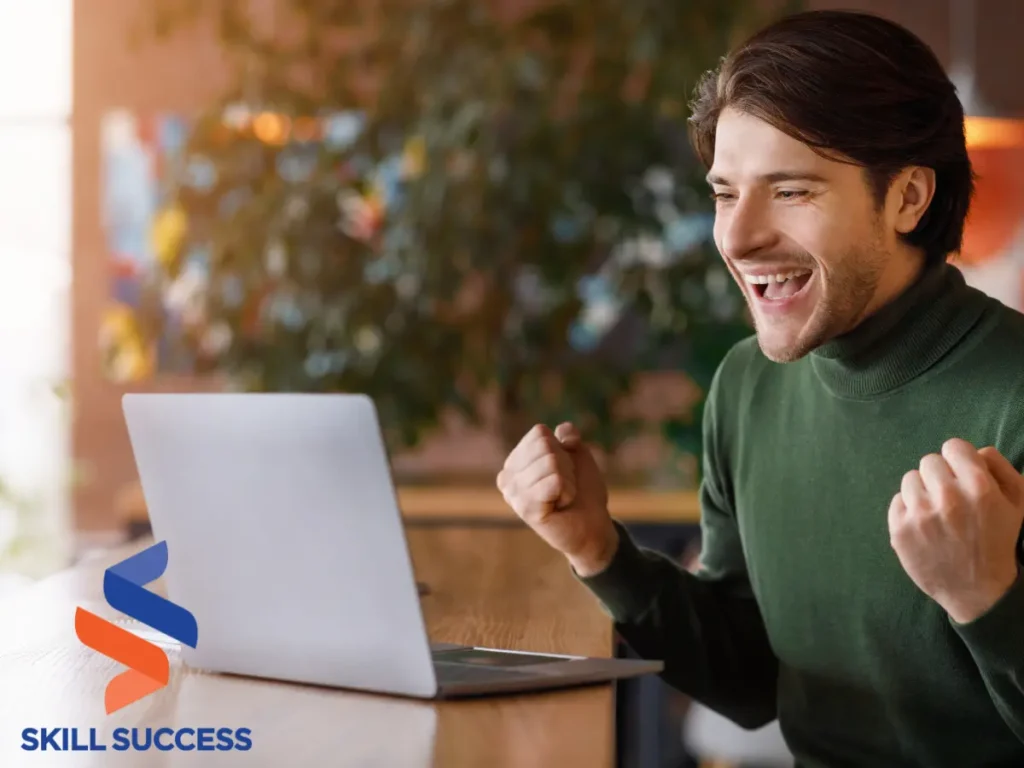 A man sits at a table with a laptop, expressing excitement about his career change at 35 years old