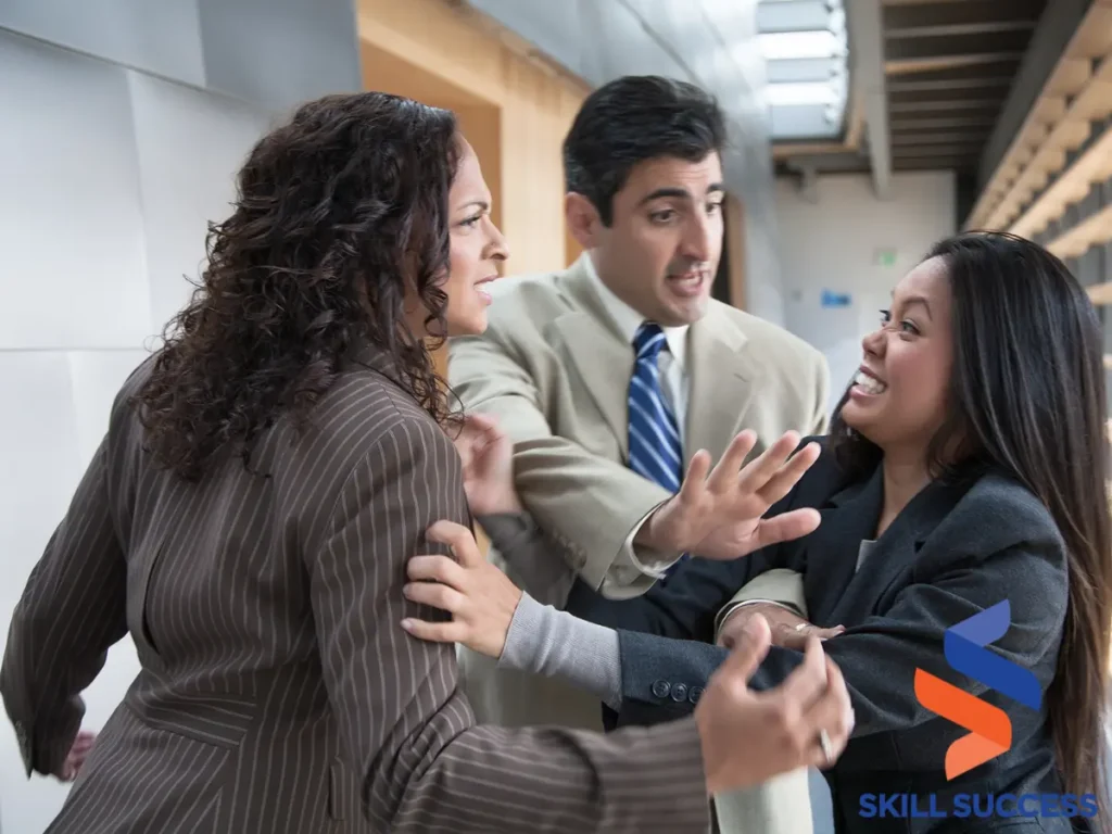 Three business people engaged in a heated argument in an office hallway, representing stages of conflict.