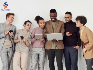 five people looking at a laptop with online training as one of the corporate training industry trends