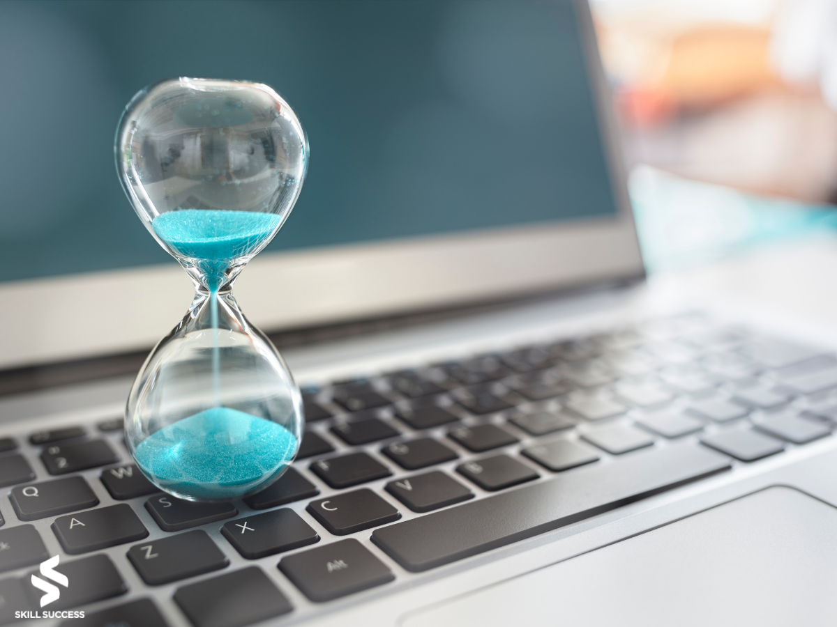 an hour glass on a laptop symbolizing productivity at work