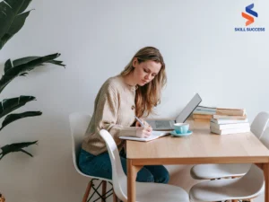 an image of a woman with a laptop, completing her training report as a new hire