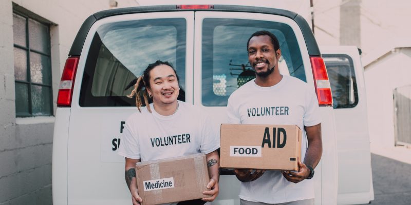Nonprofit organization volunteers Two male nonprofit organization volunteers holding boxes
