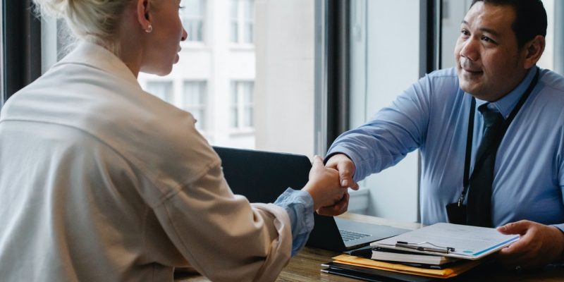 businessman shaking hands with applicant in office