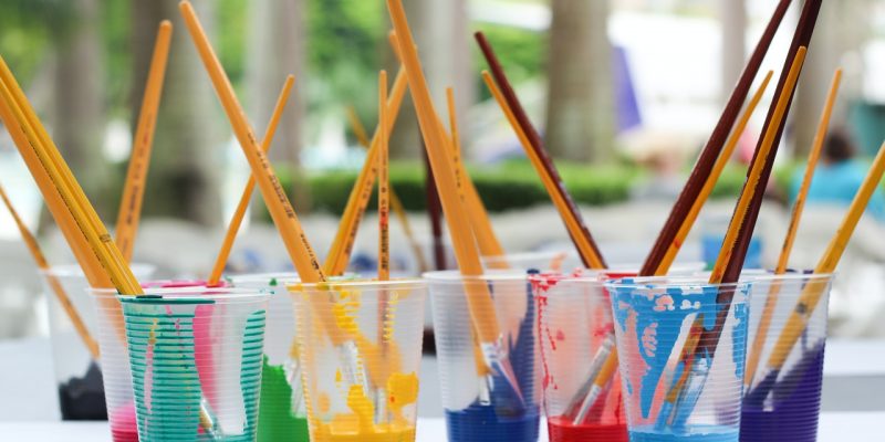 acrylic paint brushes inside clear plastic cups