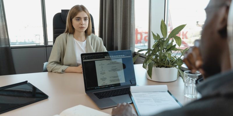 female applicant in white long sleeve shirt sitting in a job interview
